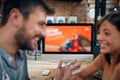 Blurred faces of young man and woman colleagues talking in front of table with desktop computer, in clothing store Royalty Free Stock Photo