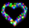 Blurred festive background with defocused colourful glitter formed a heart, bokeh in a shape of a heart. Original photographic