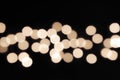 Blurred festive bokeh background with golden Christmas garland lights shot on open aperture, round defocused golden highlights Royalty Free Stock Photo