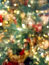 Blurred festive bright colorful New Year Christmas background. Decorated natural green fir tree with red golden silver glittering Royalty Free Stock Photo