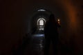 The blurred figure of a man in a hood, holding a burning candle underground corridor Royalty Free Stock Photo