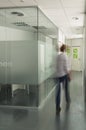 Blurred figure of a woman walking in the hallway of a modern office building Royalty Free Stock Photo