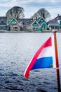 Blurred flag of the Netherlands against the background of a traditional Dutch village Royalty Free Stock Photo