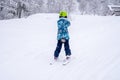 Blurred focus background. A girl lifting on the ski drag lift rope in blue sport outfit on the ski resort mountain do a ski lesson