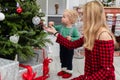 A young mother dresses a Christmas tree with her little son. Royalty Free Stock Photo