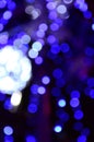 Blurred fragment of the New Year tree. Lots of round lights in blue