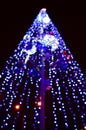 Blurred fragment of the New Year tree. Lots of round lights in blue