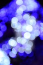 Blurred fragment of the New Year tree. Lots of round lights in blue