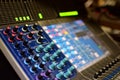 Blurred Generic Photo of Concert Music Broadcast Soundboard Mixer and Equalizer with Knobs and Audio Volume Indicator Lights Shall