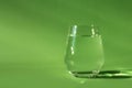 Blurred glass of clean fresh water on green background. Spring ecologically pure water. Detox, energy of still water. out of