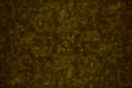 Blurred glittery texture of glitter in yellow on brown. Abstract