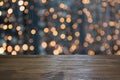 Blurred gold garland and wooden tabletop as foreground. Image for display or montage your christmas products.