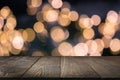 Blurred gold garland and wooden tabletop as foreground. Image for display your christmas products