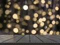 Blurred gold garland and wooden tabletop as foreground. Image for display your christmas products.