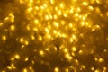 Blurred golden background with circle sparkling lights. Shiny yellow glittery bokeh of christmas garland. Dark backdrop Royalty Free Stock Photo