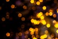 Blurred golden lights abstract background in the night, defocused dark glowing bokeh backdrop, magical yellow illuminated sparkle Royalty Free Stock Photo