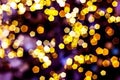 Blurred golden lights abstract background in the night, defocused dark glowing bokeh backdrop, magical yellow illuminated sparkle Royalty Free Stock Photo