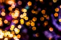 Blurred golden lights abstract background in the night, defocused dark glowing bokeh backdrop, magical yellow illuminated sparkle Royalty Free Stock Photo