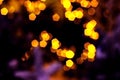 Blurred golden lights abstract background in the night, defocused dark glowing bokeh backdrop, magical yellow illuminated sparkle Royalty Free Stock Photo