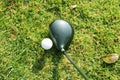 Blurred golf club and golf ball close up in grass field with sunset. Royalty Free Stock Photo
