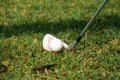 Blurred golf club and golf ball close up in grass field with sunset. Royalty Free Stock Photo