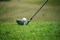 Blurred golf club and golf ball close up in grass field with sunset. Royalty Free Stock Photo