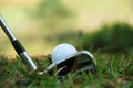 Blurred golf club and golf ball close up in grass field with sunset. Golf ball close up in golf coures Royalty Free Stock Photo