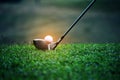 Blurred golf club and golf ball close up in grass field with sunset. Golf ball close up in golf coures Royalty Free Stock Photo