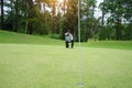 Blurred golf player at the putting green hitting ball into a hole. Golfer playing golf in beautiful golf course in thailand Royalty Free Stock Photo