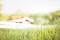 Blurred grass field with white fence and barn in background in the morning gold sun light