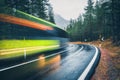 Blurred green bus on the road in autumn forest in rain Royalty Free Stock Photo