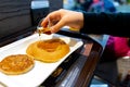 Blurred Hand pouring syrup on pancake.