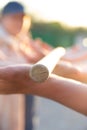 Blurred hands hold a blurred, wooden stick. teambuilding activity with a stick and hands. colleagues. rays of the sun fall, light