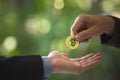 Blurred Hands of two businessmen are trading coin of bitcoin. A symbolic coins of bitcoin. Royalty Free Stock Photo