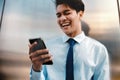 Blurred of a Happy Young Businessman Using Mobile Phone in the Urban City. Lifestyle of Modern People. Front View. Standing by the Royalty Free Stock Photo