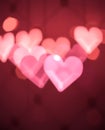 Blurred heart shaped lights create a soft and romantic glow on a dark red background Royalty Free Stock Photo