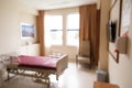 Blurred hospital indoor room with bed and window with lush sunlight