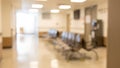 Blurred hospital waiting area with a row of chairs and bright ceiling lights Royalty Free Stock Photo