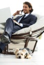 Blurred image of a businessman sitting in a chair and his little pet Royalty Free Stock Photo