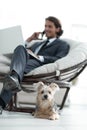 Blurred image of a businessman sitting in a chair and his little pet Royalty Free Stock Photo