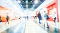 A blurred image of a convention center walkway with booth displays Royalty Free Stock Photo