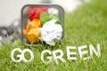 Blurred image of crumple paper in thrash can with alphabet GO GREEN Royalty Free Stock Photo