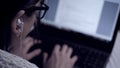 Blurred image of female hands from behind shoulder typing something on laptop keyboard. Hacker, student, freelancer Royalty Free Stock Photo