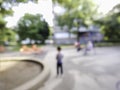 Blurred image of lone child in playground park alone boy standing on childrens playing urban city space out of focus shot of Royalty Free Stock Photo