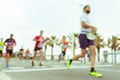 Blurred image of people running in massive marathon on a sunny summer day.