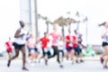 Blurred image of people running in massive marathon on a sunny summer day.