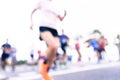 Blurred image of people running in massive marathon on a sunny summer day.