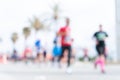 Blurred image of people running in massive marathon on a sunny summer day.