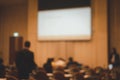 Blurred image of people sitting in conference room for seminar and screen presentation Royalty Free Stock Photo