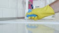 Blurred Image with Person Hands Wearing Protective Yellow Household Gloves Cleaning the Kitchen Furniture Royalty Free Stock Photo